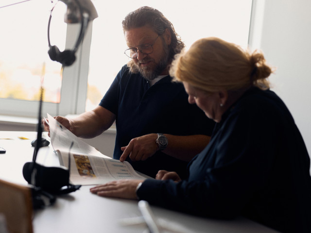 Zwei Personen lesen und besprechen ein ausgedrucktes Dokument